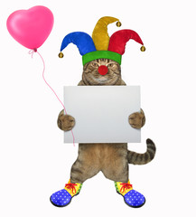 The funny cat clown in a jester hat holds the blank poster and a red balloon. White background. Isolated.