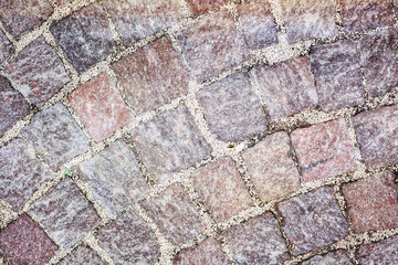 Rough texture of wet cobblestones, old side-street