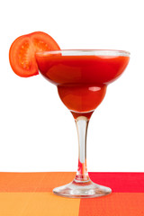 .A glass of tomato juice with a slice of tomato on a white isolated background