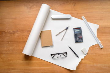 Flat lay of technical drawing setup, with pencil, compass, ruler, calculator, glasses, eraser and notebook