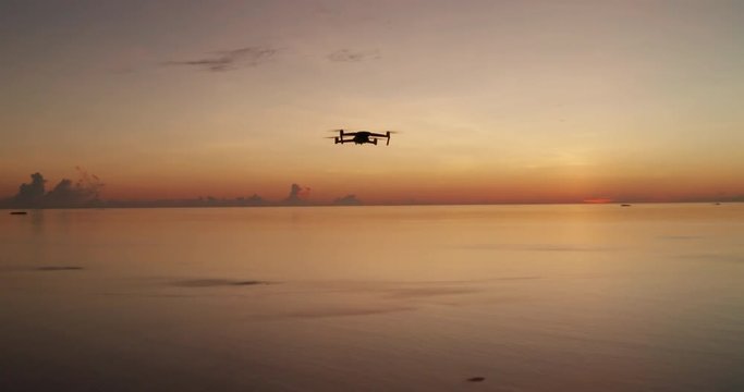 Aerial view of drone is flying on a  scenic sunset landscape of desert island with white sand beach and crystal clear sea water. 