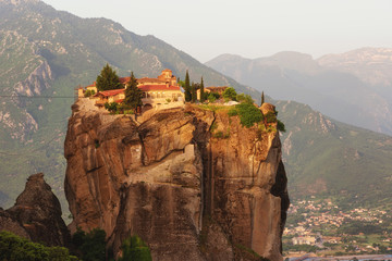 Fototapeta na wymiar Monastery Holy Trinity, Meteora, Greece. UNESCO world heritage Site. Epic spring landscape with temple at the edge of cliff at dramatic sky background.