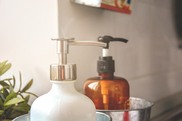 Two soap dispensers in a light room with natural sunlight.