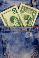Twenty dollars bill in the pocket of blue jeans