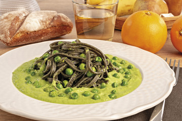 pasta al nero di seppia con salsa di piselli da sopra piatto tondo vicino