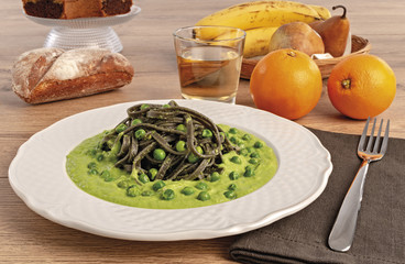 pasta al nero di seppia con salsa di piselli da sopra piatto tondo