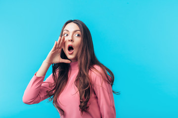 Crying emotional woman screaming holding hand near mouth on blue background