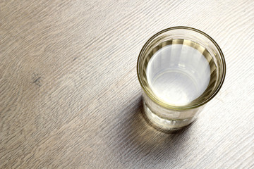 Water in a glass cup on a wooden background