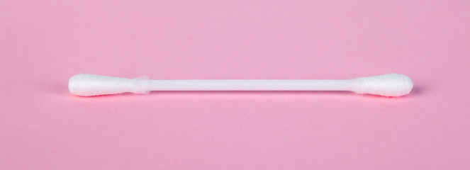 stick for cleaning ears on a pink background