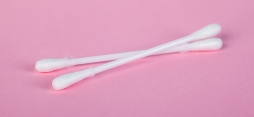 sticks for cleaning ears on a pink background