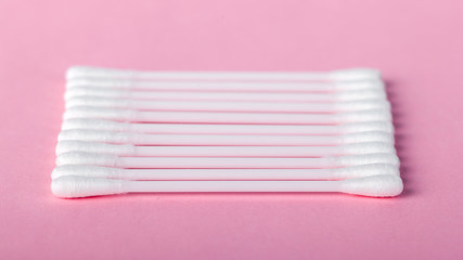 sticks for cleaning ears on a pink background