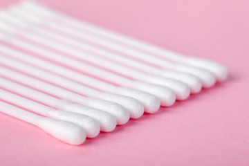 sticks for cleaning ears on a pink background