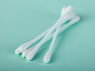 sticks for cleaning ears on a green background