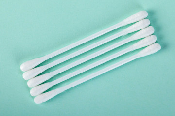 sticks for cleaning ears on a green background