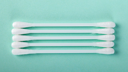 sticks for cleaning ears on a green background