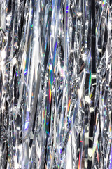 Silver shiny holographic tinsel background. Festive or party wallpaper.