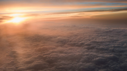 Fototapeta premium Aerial traveling. Flying at dusk or dawn. Fly through orange cloud and sun.