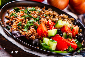 Groats with lentils and vegetables on wooden table