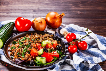 Groats with lentils and vegetables on wooden table