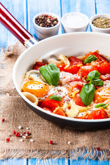 Shakshuka - fried eggs with vegetables in frying pan