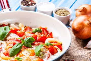 Shakshuka - fried eggs with vegetables in frying pan