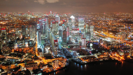 Aerial drone night shot from iconic Canary Wharf skyscrapers business area, Docklands, Isle of Dogs, London, United Kingdom