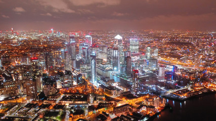 Obraz premium Aerial drone night shot from iconic Canary Wharf skyscrapers business area, Docklands, Isle of Dogs, London, United Kingdom