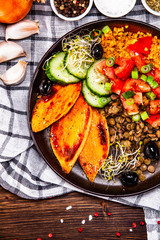 Groats with lentils and vegetables on wooden table