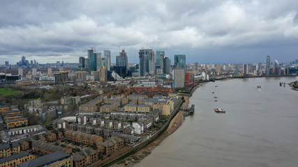 Fototapeta premium Aerial bird's eye view photo taken by drone of Canary Wharf skyline as seen from river Thames with beautiful cloudy sky, Isle of Dogs, London, United Kingdom