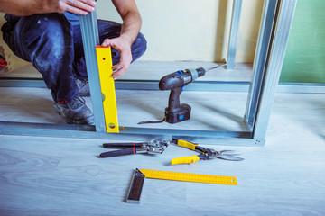 male builder installs metal ceiling profile