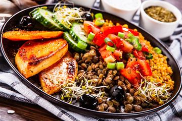 Groats with lentils and vegetables on wooden table