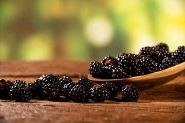 fresh blackberries in wood bowl on wooden table