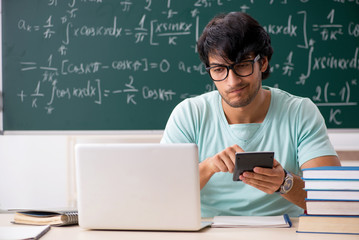 Young male student mathematician in front of chalkboard