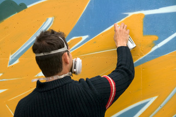 Fototapeta na wymiar Graffiti Artist Drawing Graffiti on Wall