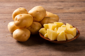 Potatoes and potato sliced on wooden table. Selective focus
