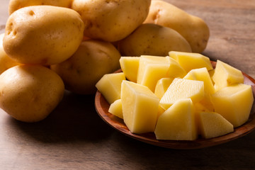 Potatoes and potato sliced on wooden table. Selective focus