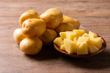 Potatoes and potato sliced on wooden table. Selective focus