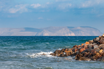 Beautiful view of the Mediterranean Sea from beach of the island of Crete. In the distance in a gaze the island is visible