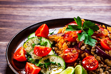 Groats with lentils and vegetables on wooden table