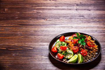 Groats with lentils and vegetables on wooden table