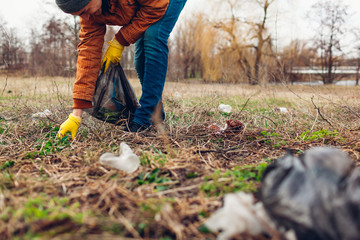 Man volunteer cleaning up the trash in park. Picking up litter outdoors. Ecology and environment concept