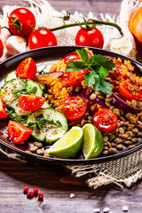 Groats with lentils and vegetables on wooden table