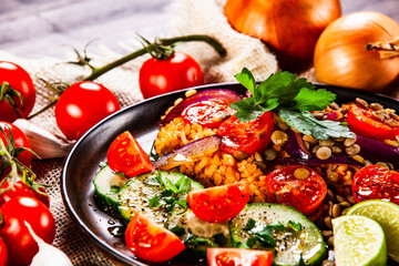 Groats with lentils and vegetables on wooden table