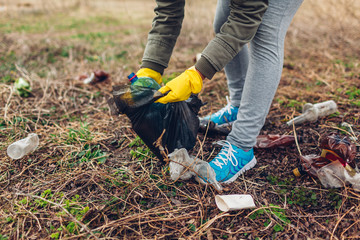 Woman volunteer cleaning up the trash in park. Picking up rubbish outdoors. Ecology and environment...
