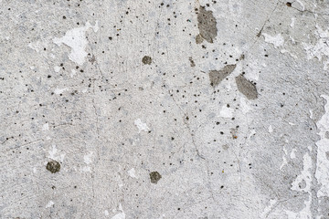 Macro texture of peeled paint on a white concrete wall.