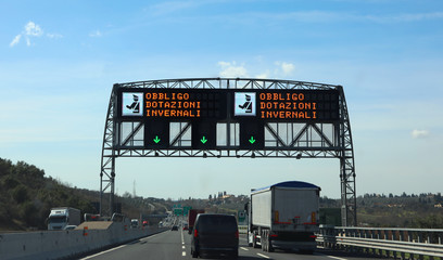 electronic road sign with text that means Winter Equipment Oblig