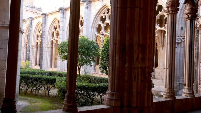 Gothic vaulted arcade with decorated ogival openings in cloister of Monastery of Santa Maria de Santes Creus, Aiguamurcia, Spain