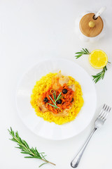 Couscous with fish and vegetables on a white plate