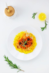 Couscous with fish and vegetables on a white plate
