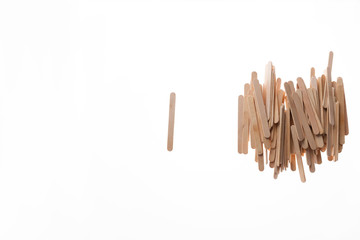 One and many wooden ice cream sticks in heap on white background. Concept gray crowd  and individual